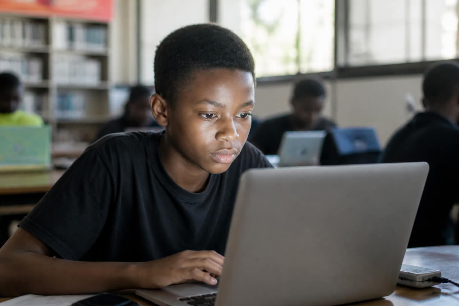 Learner coding on a laptop in a community hub